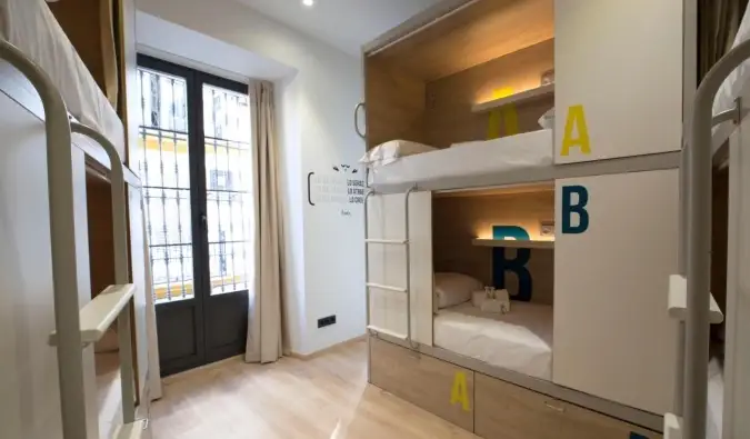 Literas modernas estilo cápsula en una habitación muy iluminada en For You Hostel en Sevilla, España