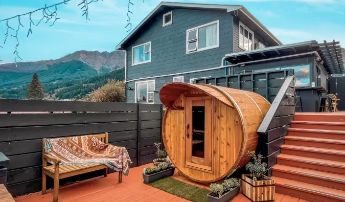 Bolvormige sauna op een terras met een groot huis op de achtergrond bij Black Sheep Backpackers hostel in Queenstown, Nieuw-Zeeland