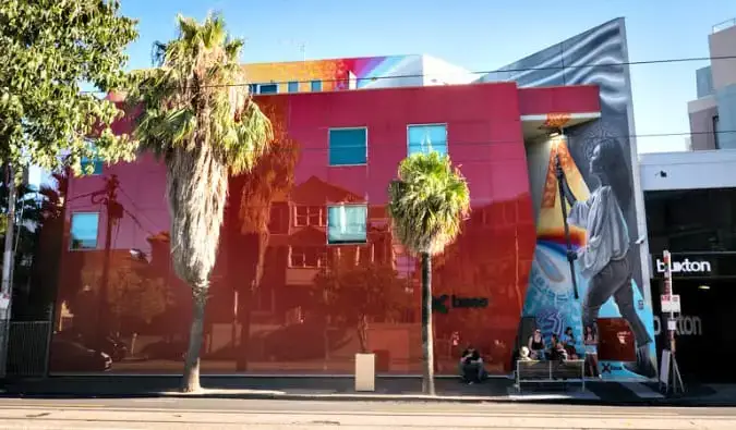 Exterior do albergue Base St. Kilda, agora Nomads, na Austrália, um prédio vermelho com um mural colorido