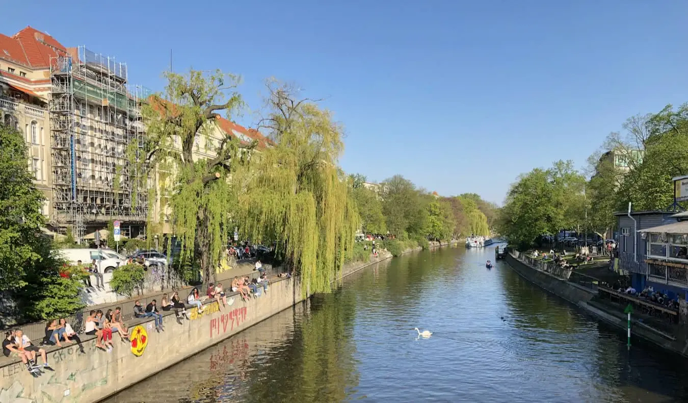 Lokalbefolkningen kopplar av nära floden i den charmiga stadsdelen Kreuzberg i Berlin, Tyskland