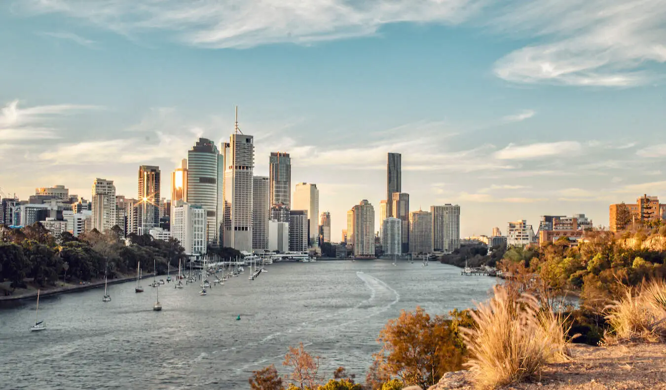 Cakrawala pusat kota Brisbane yang menjulang tinggi terlihat dari atas sungai pada hari yang cerah di Australia