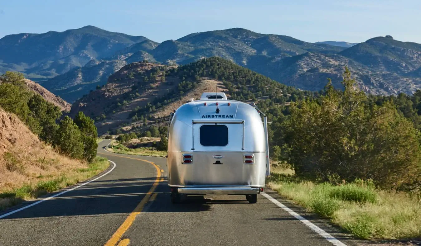 Một chiếc RV airstream cũ đang di chuyển trên con đường rộng mở ở Hoa Kỳ