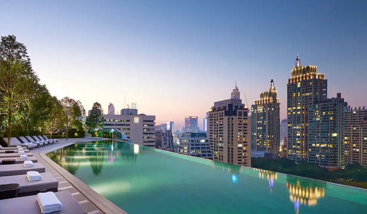 La piscina a sfioro del Park Hyatt al tramonto si affaccia sullo skyline di Bangkok, Tailandia