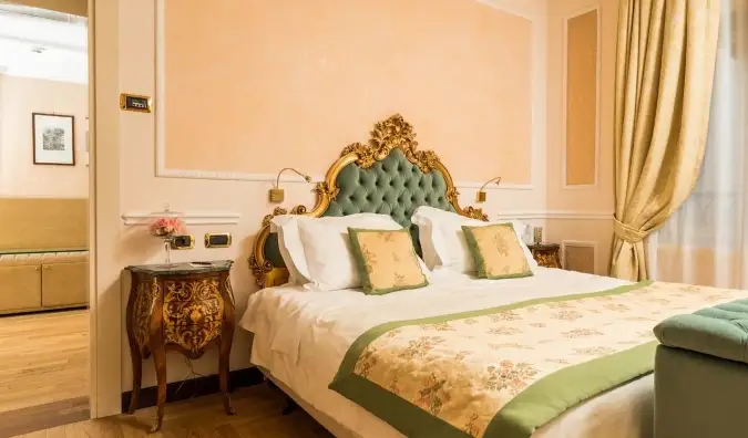 Uma cama luxuosa com cabeceira dourada no Hotel Bernini Palace, um hotel cinco estrelas em Florença, Itália