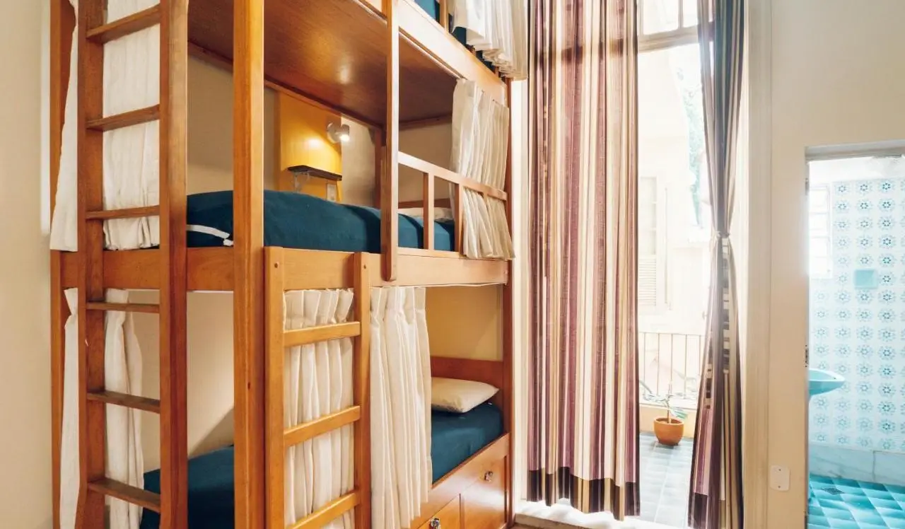 Three-tier wooden bunk bed sa Discovery Hostel sa Rio de Janeiro, Brazil