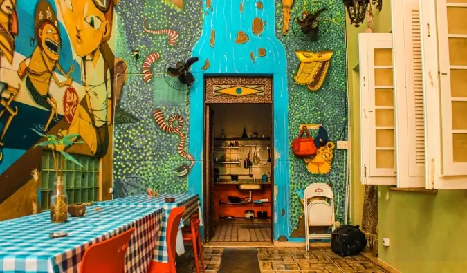 Ljust färgat kök täckt av väggmålningar på Books Hostel i Rio de Janeiro, Brasilien