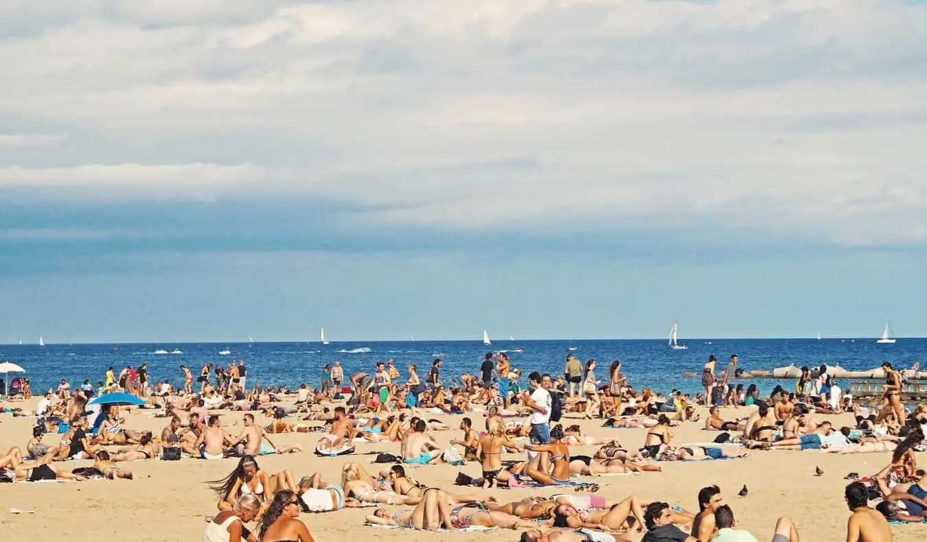 Människor som kyler på stranden i Barcelona, ​​Spanien