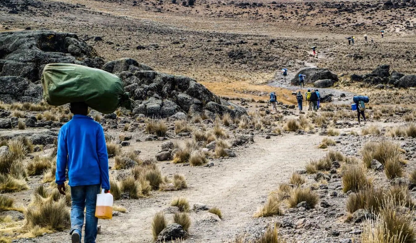 Seorang portir Kilimanjaro membawa karung besar di kepalanya