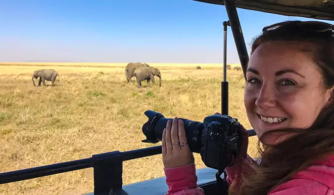 En kvinnelig alenereisende som tar bilder på safari i Afrika