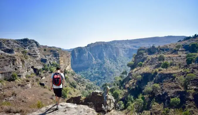 Nomadiske Matt iført ryggsekk og vandrer nær en klippe på Madagaskar