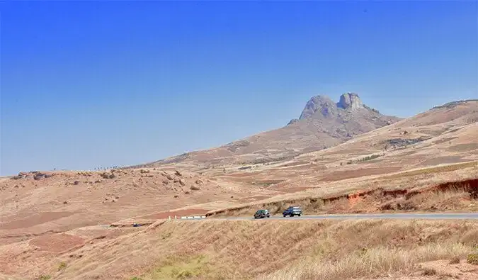 Een ruige weg in Madagaskar die door het dorre landschap snijdt