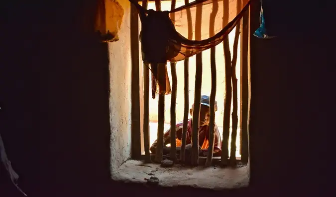 Ein kleiner Junge schaut durch ein Fenster in Madagaskar