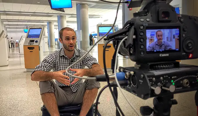 Scott filmt ein Fernsehinterview auf einem leeren Flughafen