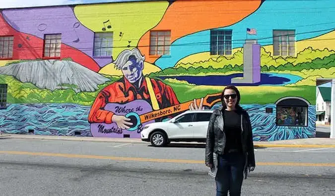 Caroline Eubanks davanti a un murale per Doc Watson a Wilkesboro, Carolina del Nord