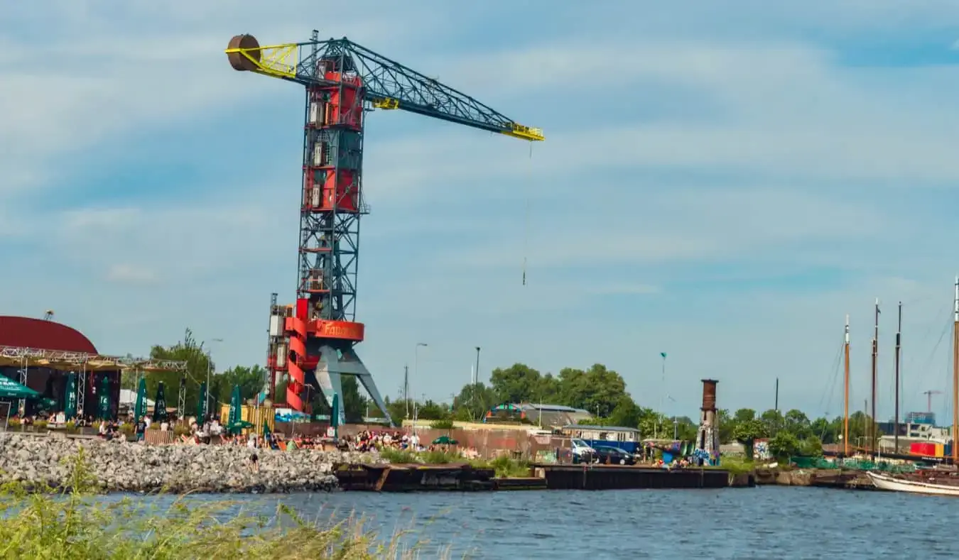 Ein hoch aufragender Kran mit Blick auf das Wasser am NDSM Wharf in Amsterdam, Niederlande