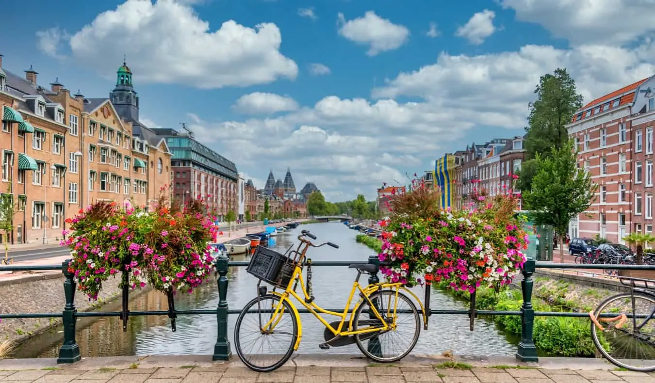 O bicicletă sprijinită de balustrada canalelor emblematice din Amsterdam, Țările de Jos