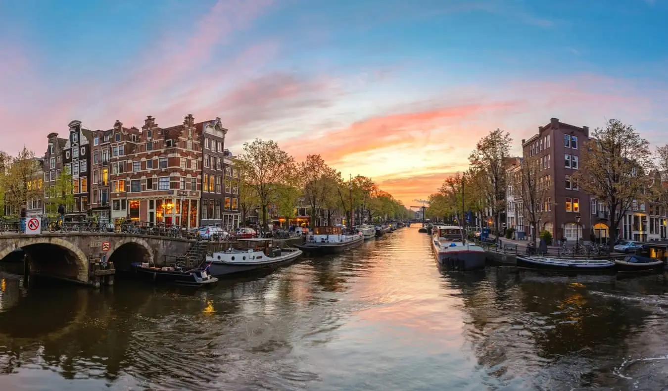 En naturskjønn tom kanal ved solnedgang i Amsterdam, Nederland