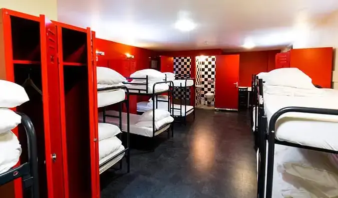 Dormitorio con paredes de color rojo brillante y muchas literas en The Bulldog Hotel