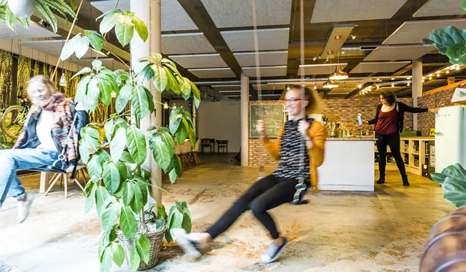 Menschen schaukeln drinnen im Ecomama Amsterdam