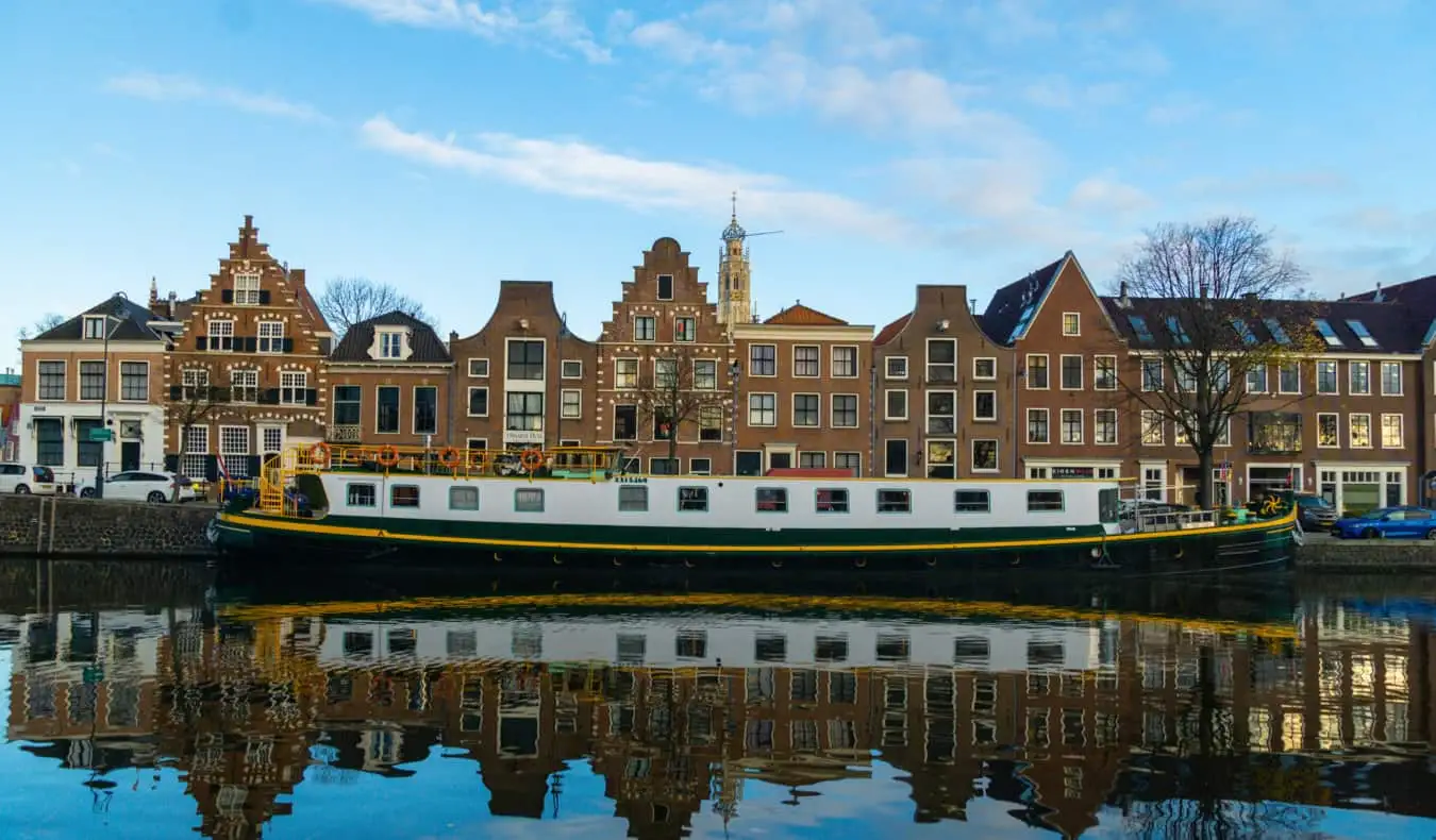 Větrný mlýn podél vody v Haarlem, Amsterdam, Nizozemsko