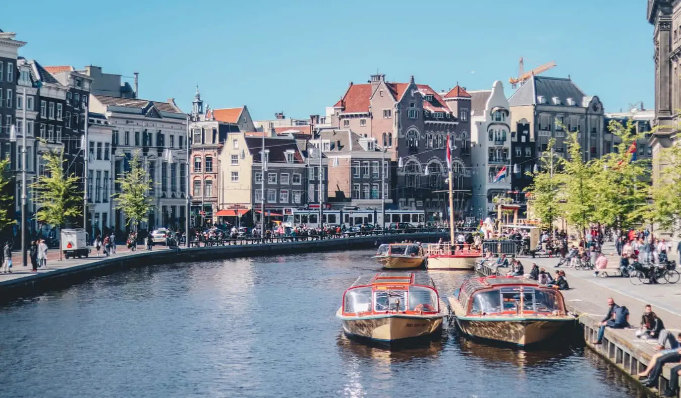 Isang makitid na kanal na may mga bangka sa Amsterdam sa isang maaraw na araw ng tag-araw