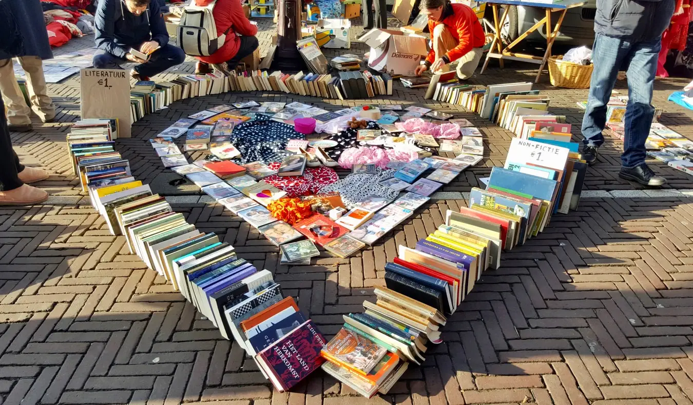 Boeken en kleding te koop op de vlooienmarkt op het Waterlooplein in Amsterdam, Nederland