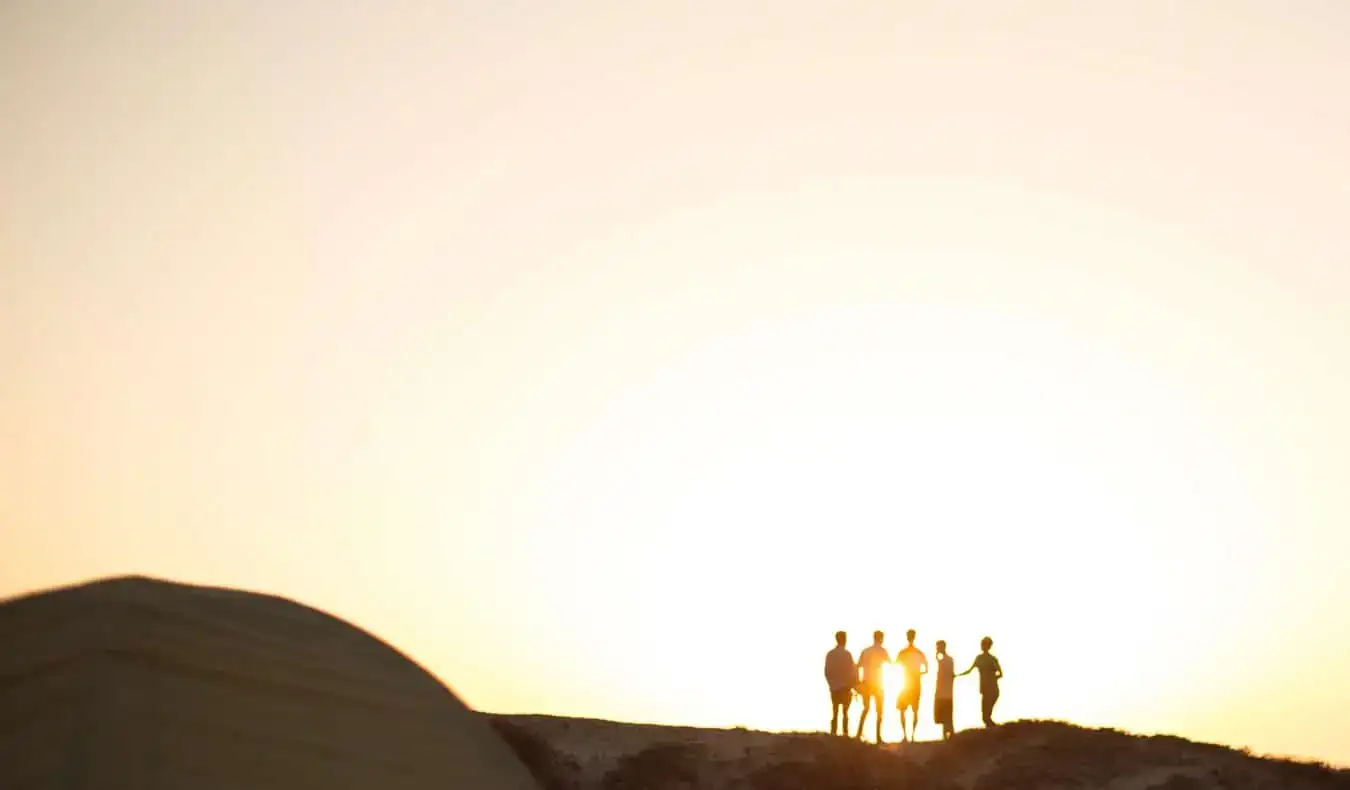 Un gruppo di viaggiatori su una montagna durante l'alba