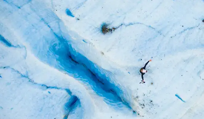 Drono kadras, kuriame Kristin Addis stovi ant Exploradores ledyno Patagonijoje