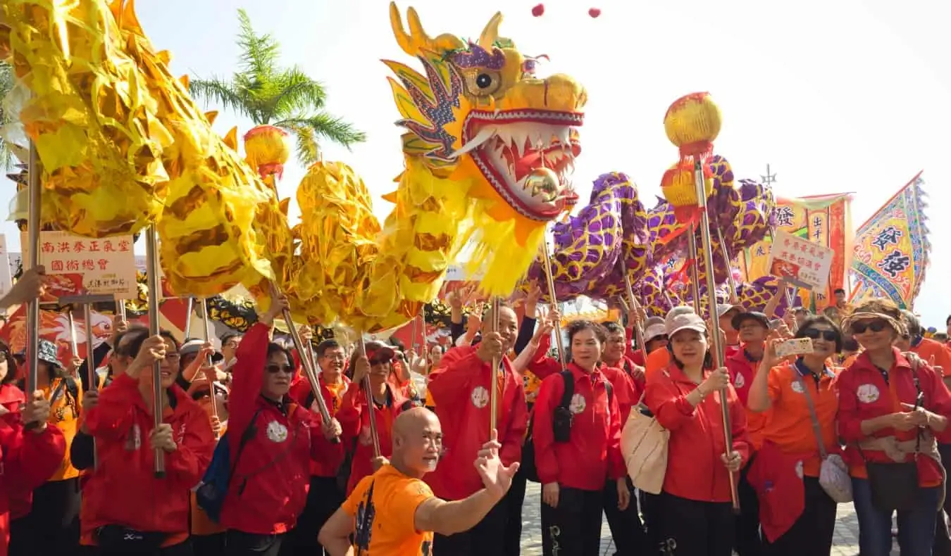 Ihmiset pitävät pystyssä suuria paperilohikäärmeitä festivaaleilla Hongkongissa