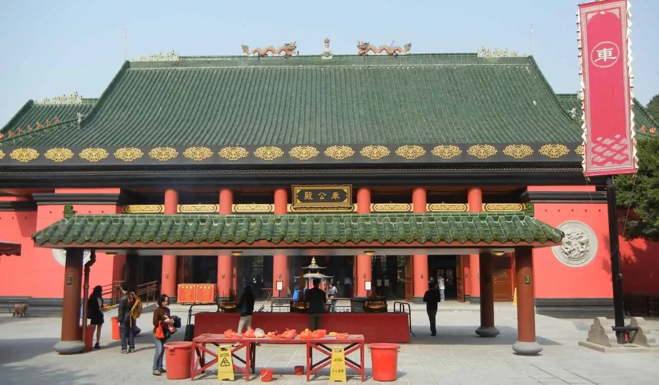 El temple Sha Tin Che Kung amb el seu exterior vermell i sostre de terracota verda a Hong Kong