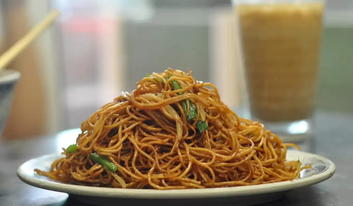 Um prato de macarrão de Hong Kong sobre uma mesa branca