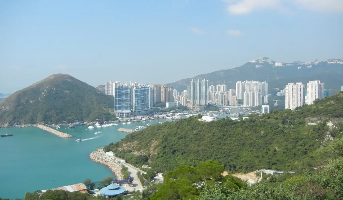 Den skyskraperfylte skyline av Hong Kong, omgitt av bølgende åser