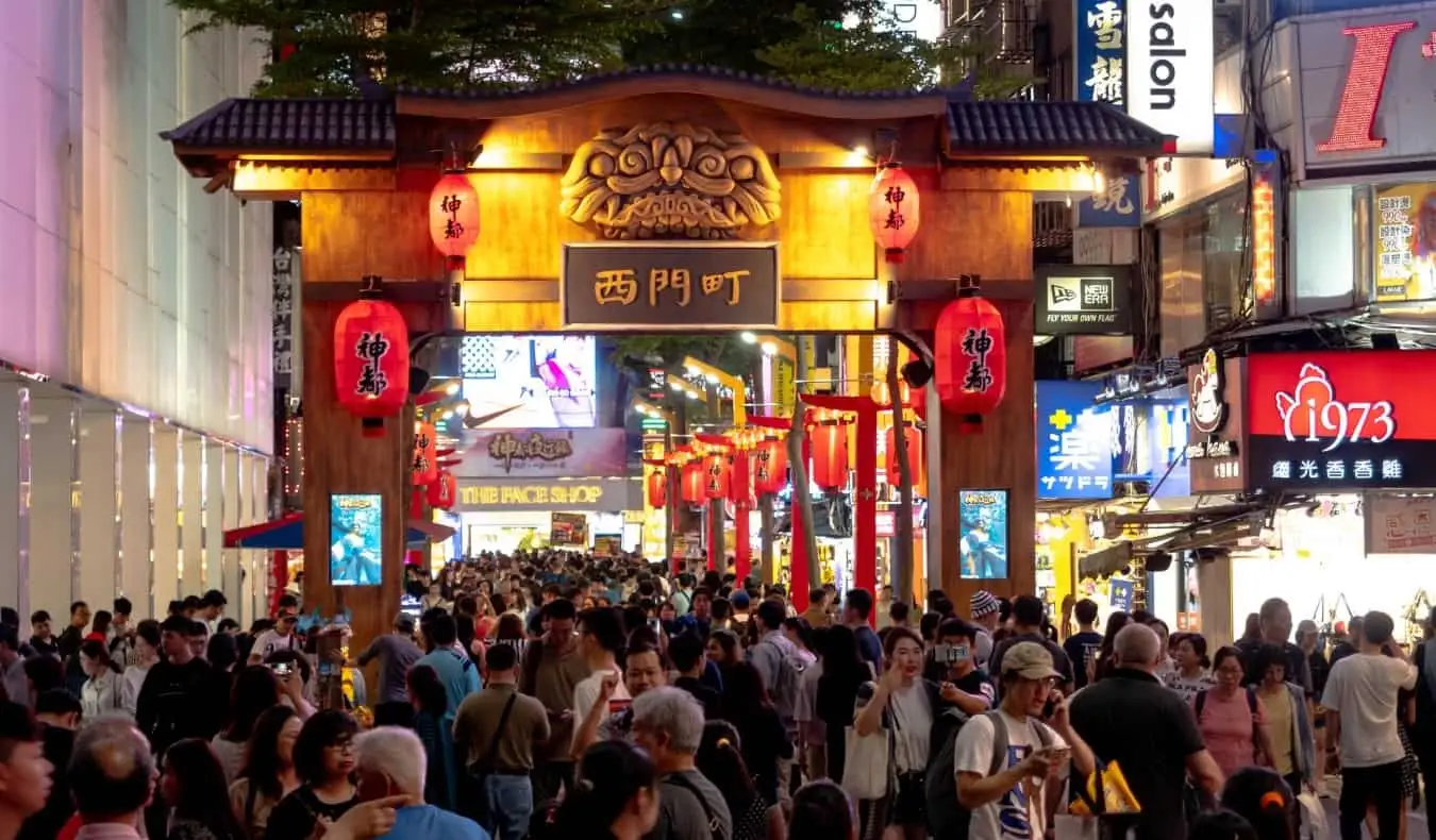 Mulțimi de oameni merg pe sub o arcadă tradițională din cartierul Ximending Taipei, Taiwan