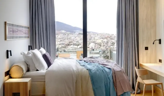 Habitació senzilla però acollidora del Coco-Mat Hotel amb finestrals amb vista sobre la ciutat d'Atenes, Grècia