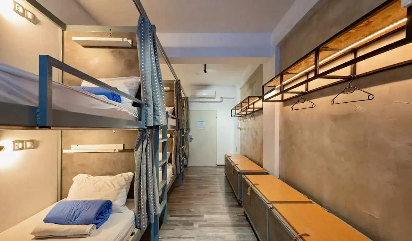 Hyggelige senge med gardiner i et kollegieværelse på Bedbox hostel i Athen