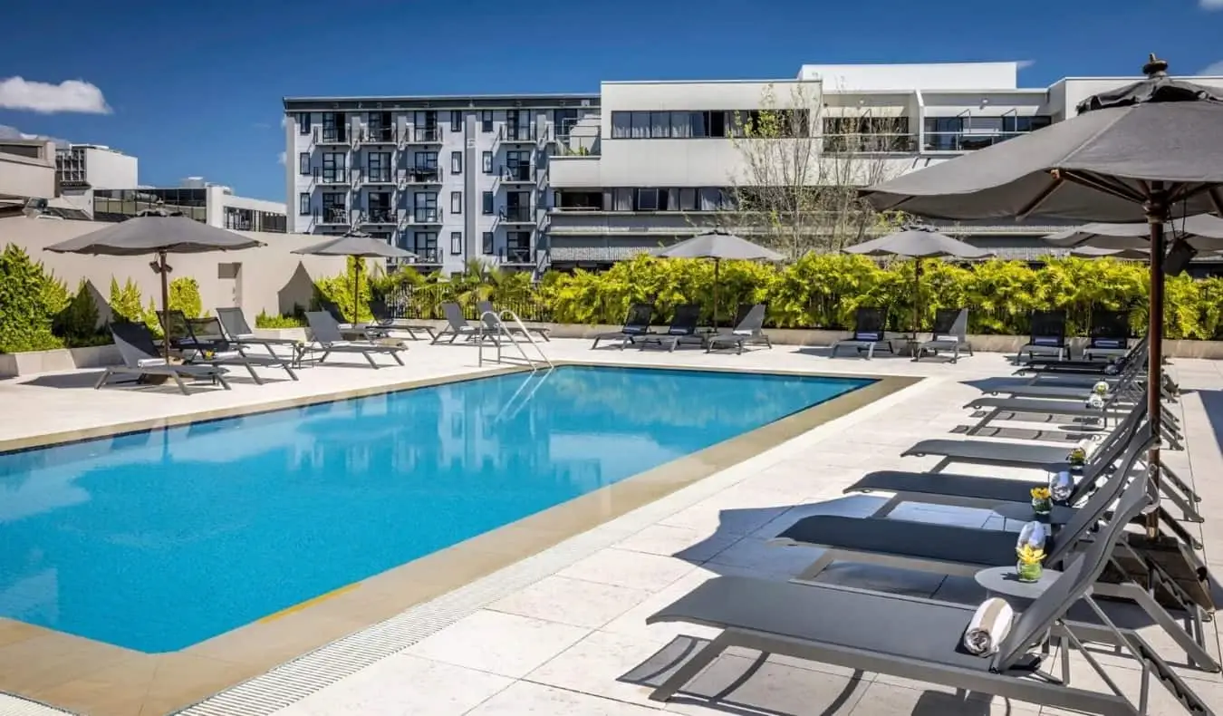 Udendørs pool omgivet af liggestole på Cordis hotel i Auckland, New Zealand