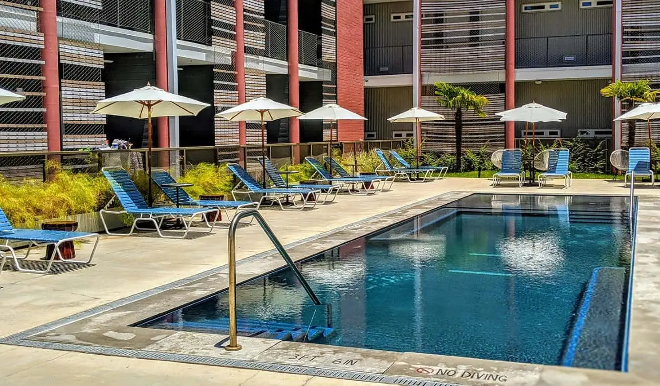 Pequeña piscina al aire libre rodeada de tumbonas en el East Austin Hotel