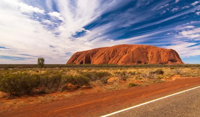 Le célèbre rocher d'Uluru en Australie, vu depuis la route voisine