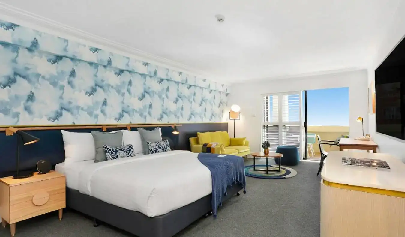 Duży pokój hotelowy z tapetą inspirowaną oceanem w hotelu Coogee Bay w Sydney w Australii