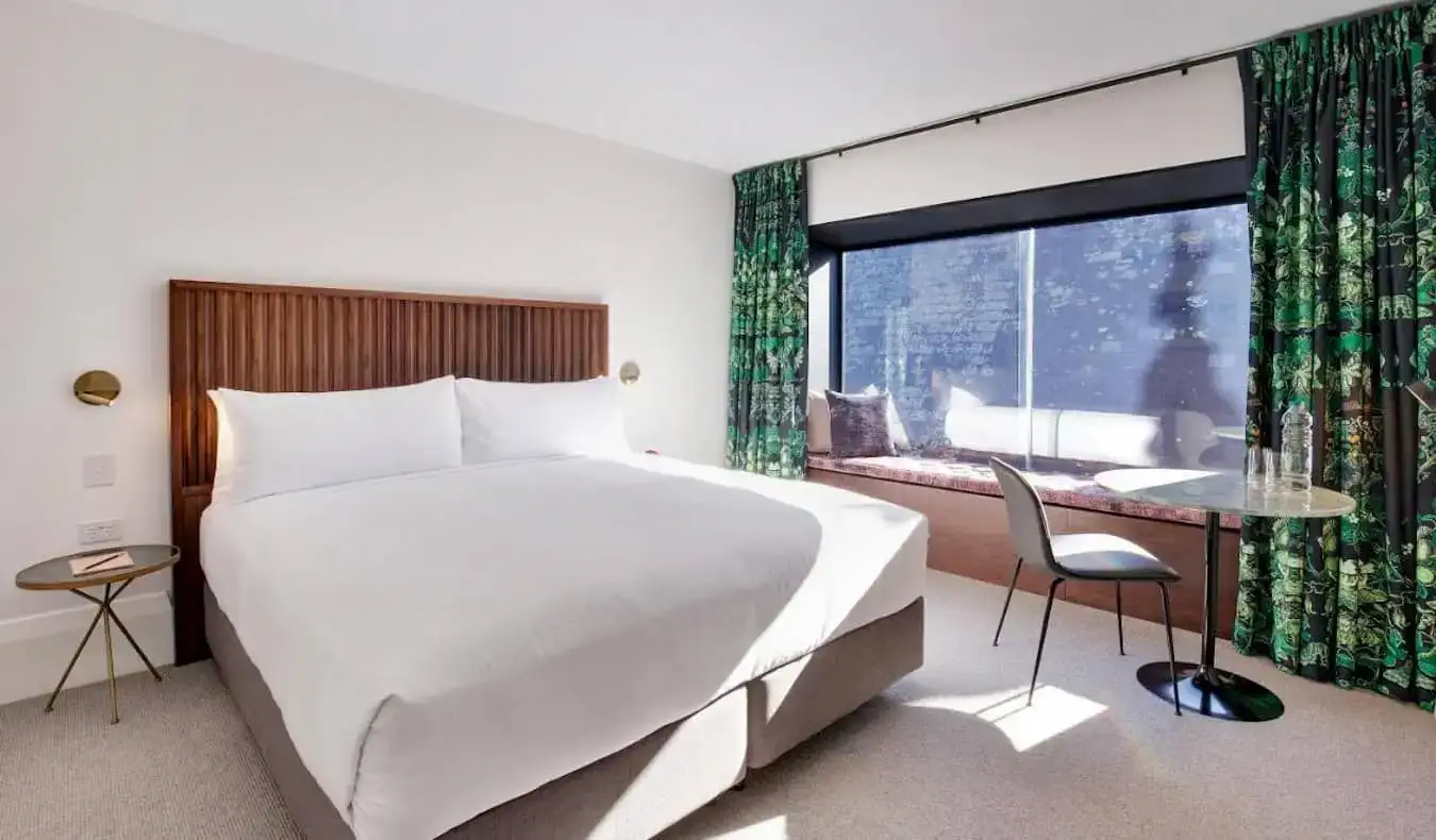 Una habitación de hotel grande y espaciosa con una cama enorme en el Crystalbrook Albion en Sydney, Australia