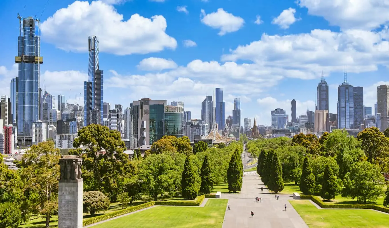 Orang-orang menjelajahi taman terbuka lebar dekat tugu peringatan perang di Melbourne yang cerah, Australia