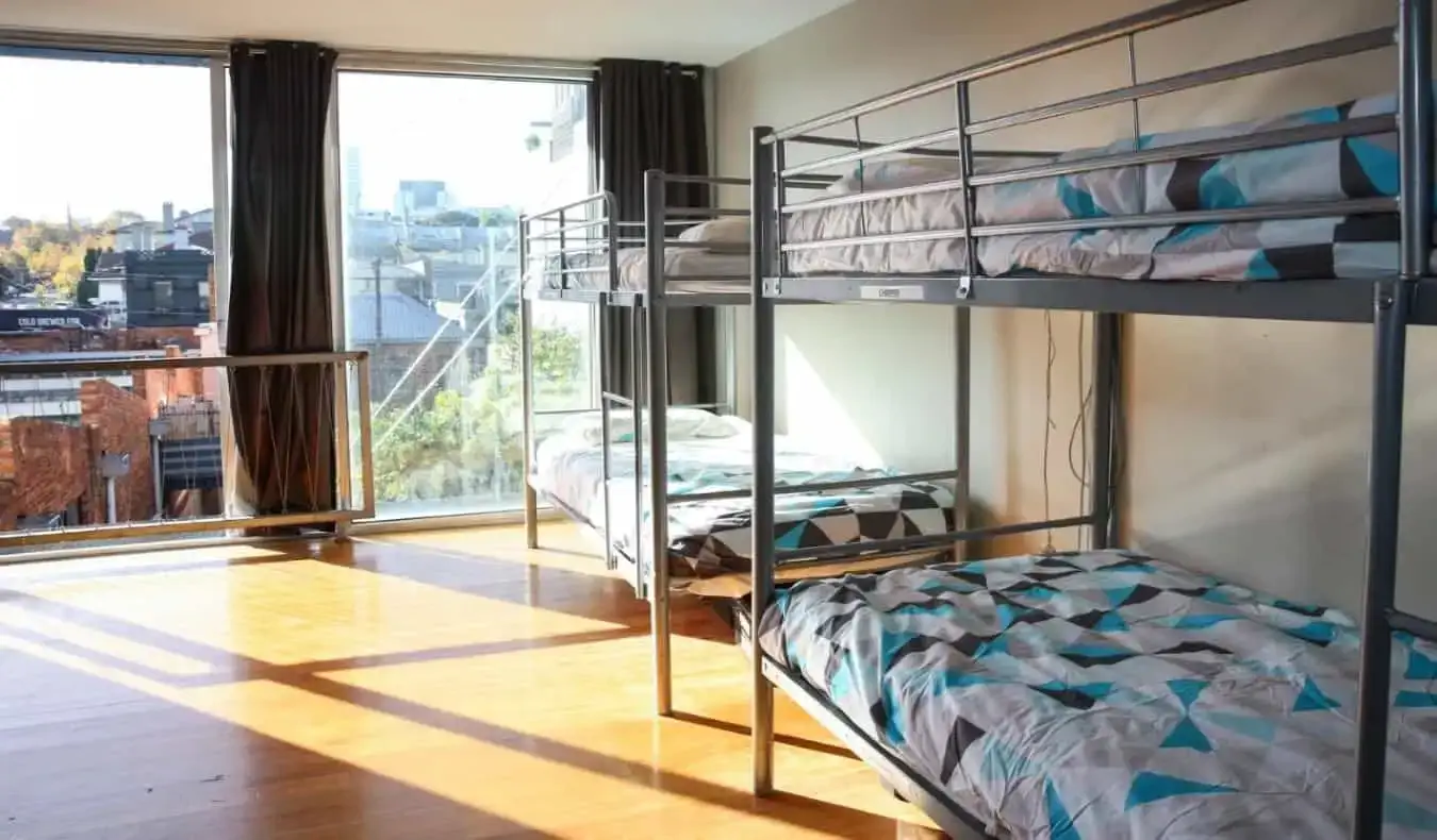 Tempat tidur susun berwarna-warni di kamar asrama yang terang di asrama Barkly Backpackers di Melbourne, Australia.