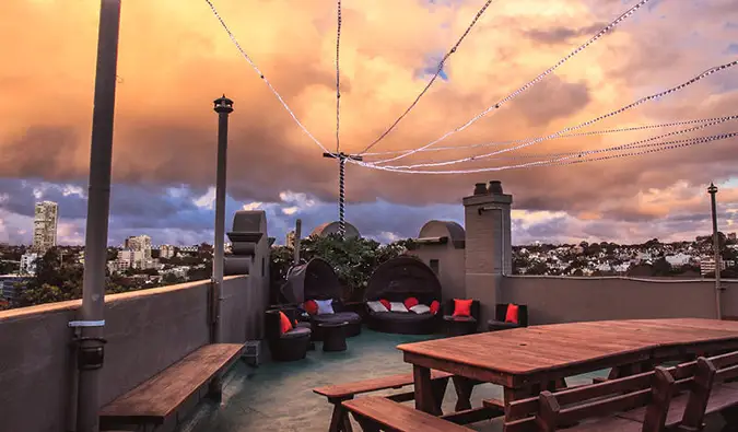 Teres atas bumbung dengan meja berkelah pada waktu matahari terbenam di Kings Cross Backpackers di Sydney, Australia