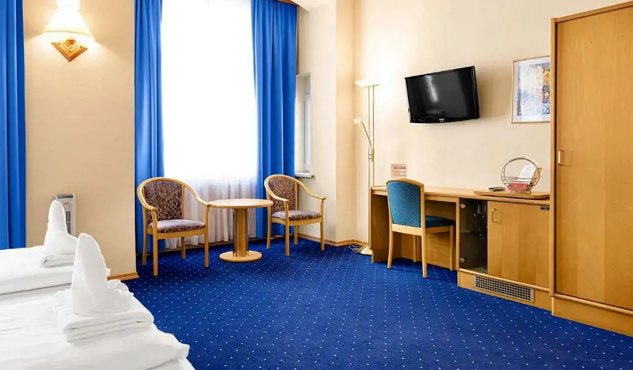 Um quarto de hotel com carpete azul no Hotel-Pension Wild em Viena, Áustria