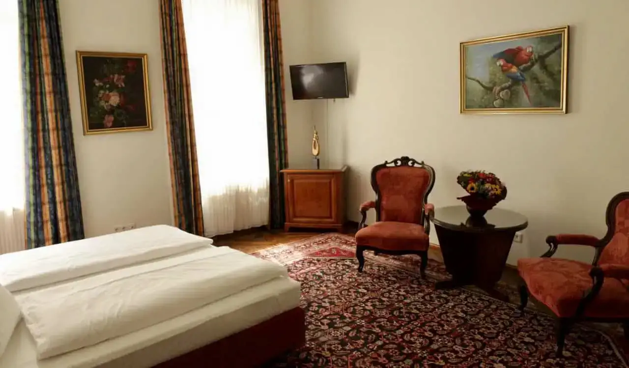 Um charmoso quarto de hotel com móveis antigos no Hotel Domizil em Viena, Áustria