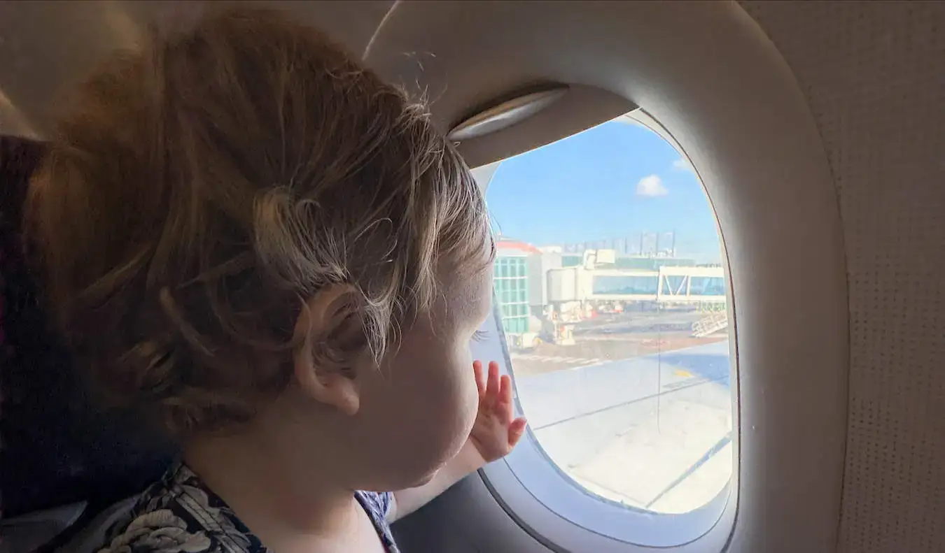 Un bambino che guarda fuori dal finestrino di un piccolo aereo