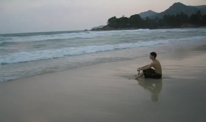 Nomadic Matt refletindo em uma praia na Tailândia