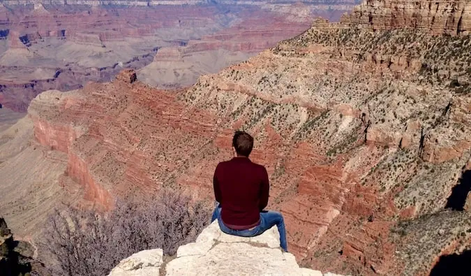 Mark Manson sitter på kanten av Grand Canyon i USA