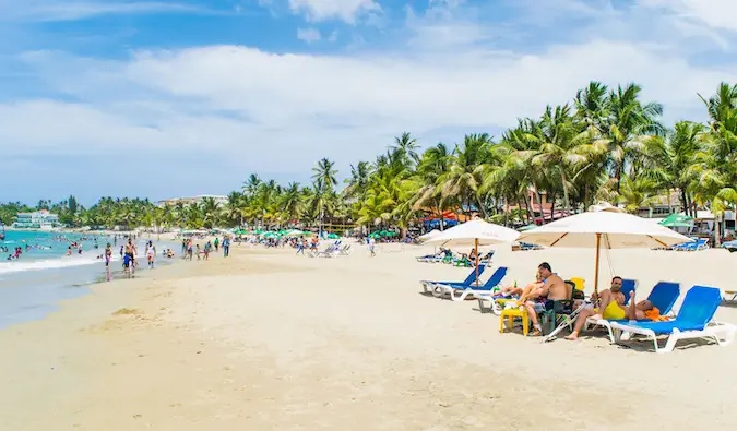 orang-orang bersantai di kursi pantai di pantai yang ramai