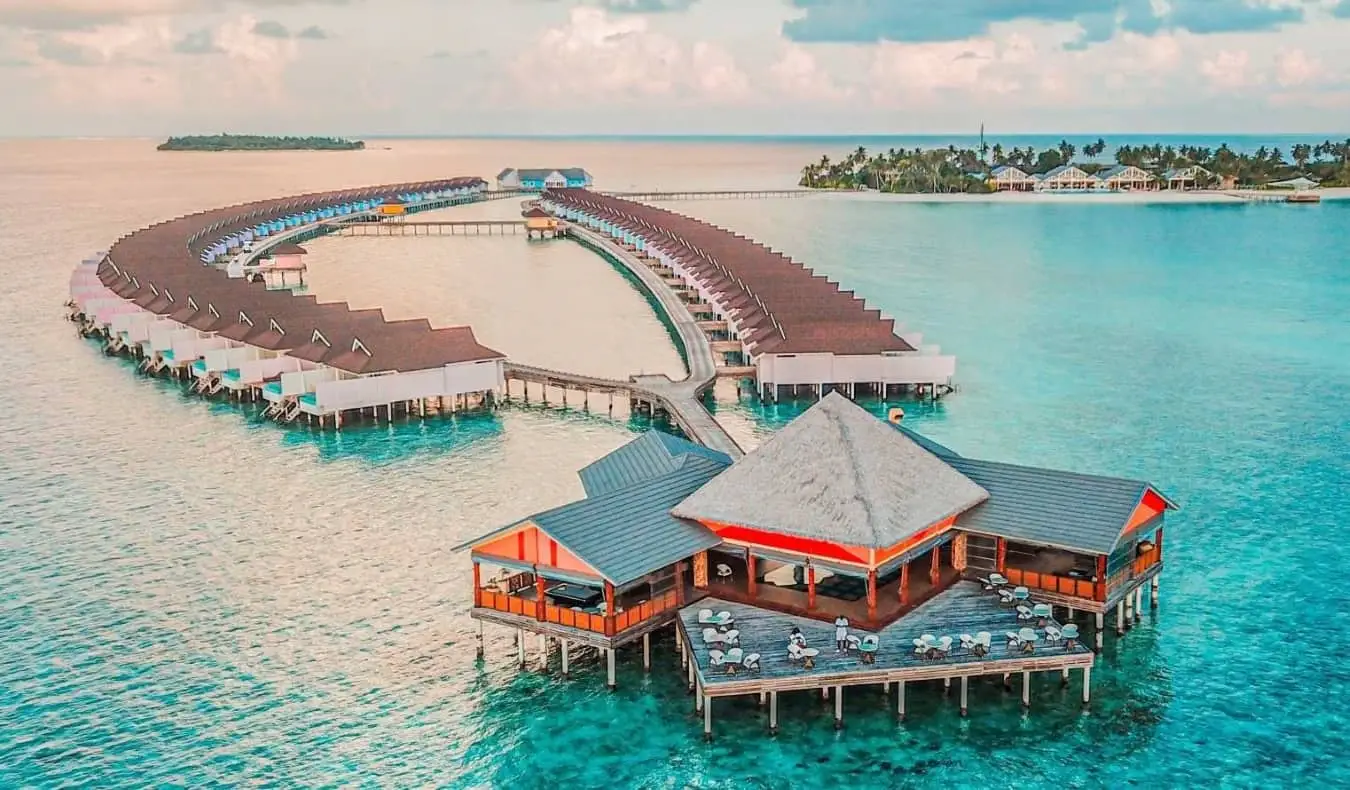 Les superbes eaux bleues tropicales claires des Maldives le long d'une étroite plage de sable blanc